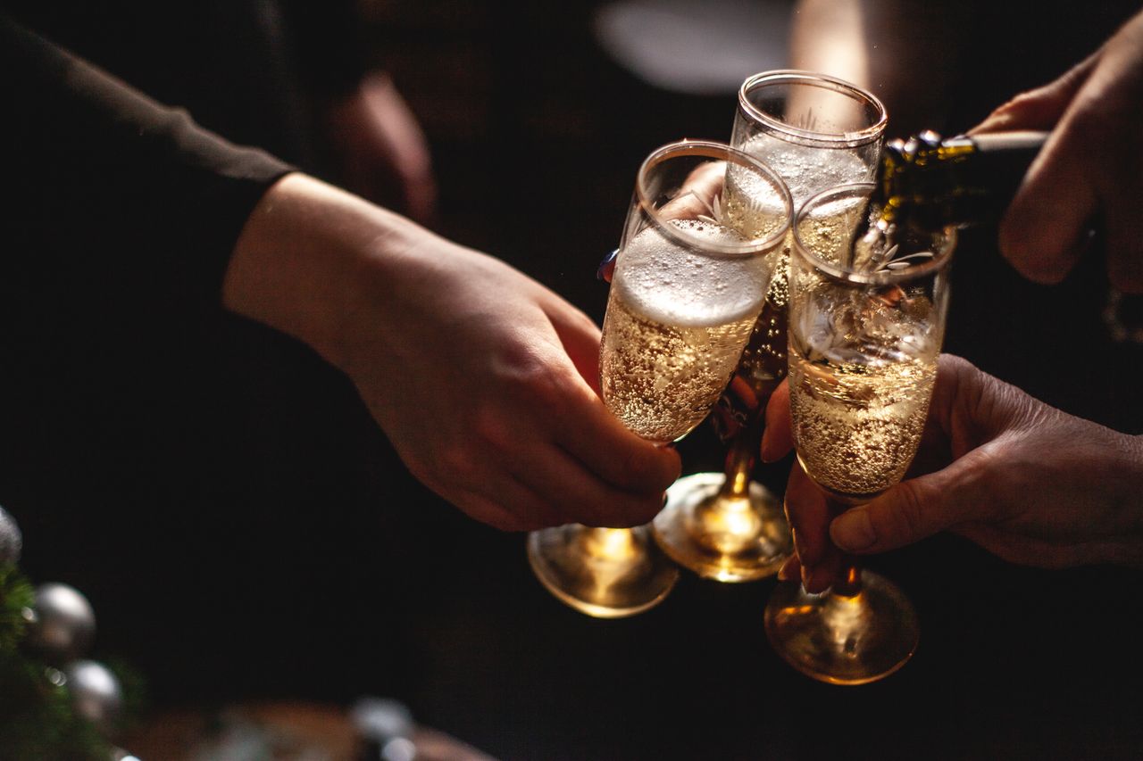 Home Close-up of hands toasting with champagne glasses, capturing celebration and joy.